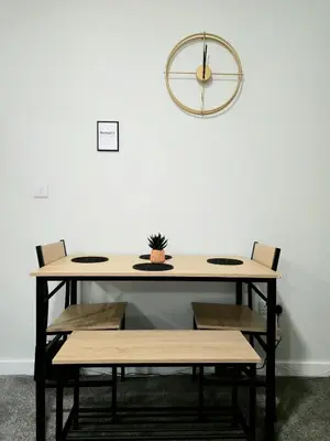 a table with chairs and a clock on the wall at 3-Bed Home in Glasgow in Glasgow