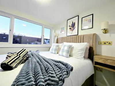 a bedroom with a bed with a blanket and a window at 3-Bed Home in Glasgow in Glasgow