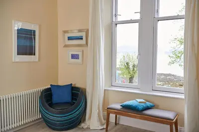 a room with a chair and a window at Swan Cove Apartment Gourock in Gourock