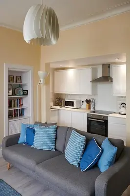 a living room with a gray couch with blue pillows at Swan Cove Apartment Gourock in Gourock