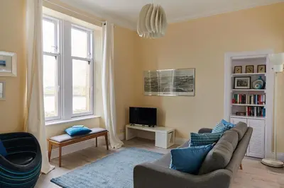 a living room with a couch and a tv at Swan Cove Apartment Gourock in Gourock