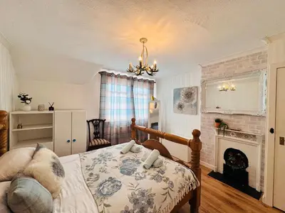 a bedroom with a bed and a fireplace at Bright 3 bedroom house with private garden near Edinburgh - Woodside home in Rosyth