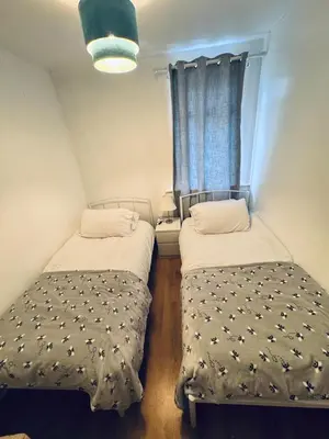 two beds in a small room with a window at Bright 3 bedroom house with private garden near Edinburgh - Woodside home in Rosyth