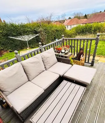 a couch sitting on top of a deck at Bright 3 bedroom house with private garden near Edinburgh - Woodside home in Rosyth
