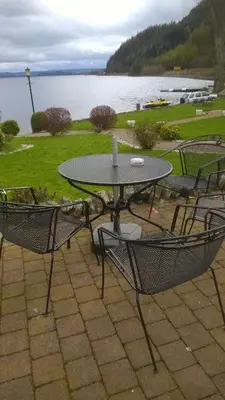a patio table and chairs with a view of a lake at Culag Lochside Self Catering in Luss