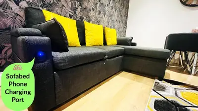 a black couch with yellow pillows in a living room at Ground Floor Entire Apartment Self Checkin in Crossgates