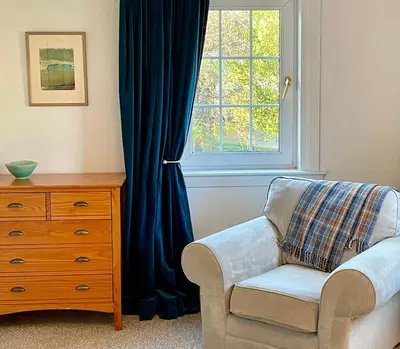 a living room with a chair and a window at A 2 Bedroom flat in Culross home of Outlander in Culross