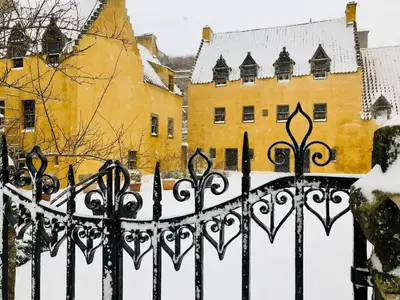 a fence in the snow with buildings in the background at A 2 Bedroom flat in Culross home of Outlander in Culross