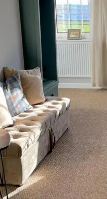 a couch sitting in a living room with a window at A 2 Bedroom flat in Culross home of Outlander in Culross