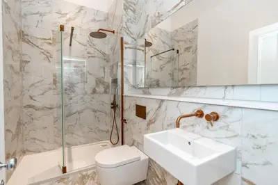 a bathroom with a sink and a toilet and a shower at Dragon Suites Luxury Apartments at 8 Albyn Place in Edinburgh