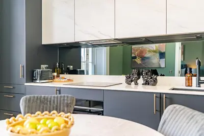 a kitchen with a table with a bowl of fruit on it at Dragon Suites Luxury Apartments at 8 Albyn Place in Edinburgh