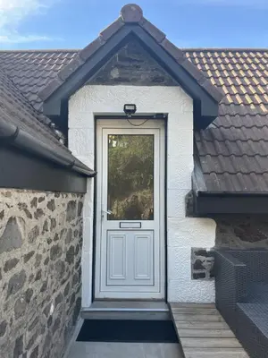 a door in a house with a stone wall at Dun-Niall Apartment in Oban