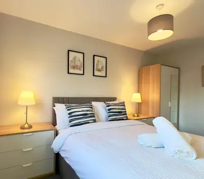 a bedroom with a large white bed with two lamps at Chic & Cozy 2-Bed Flat in Glasgow - Free Parking in Glasgow