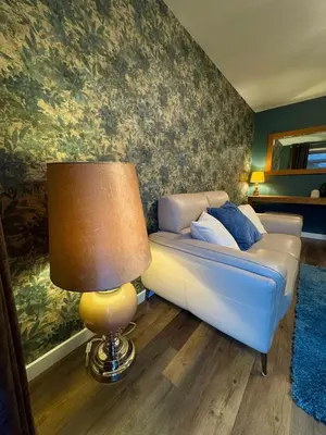a living room with a couch and a lamp at Cochrane House in Stirling