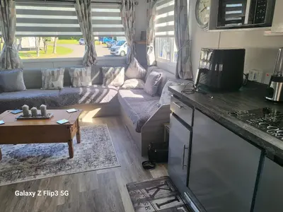 a living room with a couch and a table at MLR at Craig Tara Bay View in Ayr