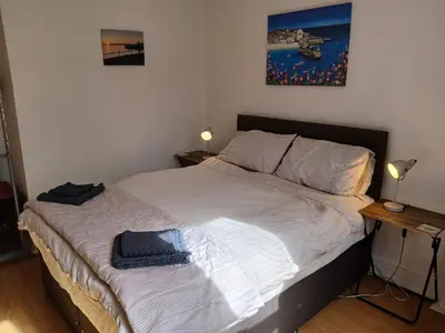 a bed in a bedroom with a picture on the wall at Sunset of Largs in Largs