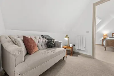 a living room with a couch with pillows on it at Luxury 3 Bedroom Cottage in Centre of Killin in Killin