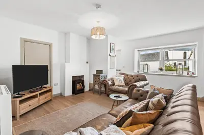 a living room with a couch and a flat screen tv at Luxury 3 Bedroom Cottage in Centre of Killin in Killin