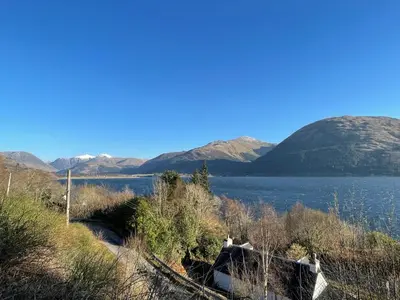 a view of a lake with mountains in the background at Old Springwell Croft in Onich