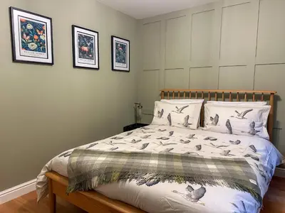 a bedroom with a bed with birds on it at Coorie Neuk in Cairnbaan
