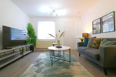 a living room with a couch and a tv at Signature - Thorn House in Coatbridge