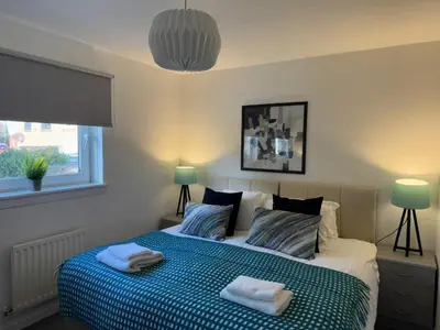 a bedroom with a bed with two towels on it at Signature - Thorn House in Coatbridge