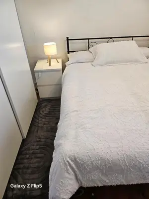 a bedroom with a bed and a lamp on a night stand at Double room available in Livingston