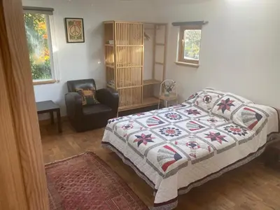 a bedroom with a bed and a chair at Garden Retreat in Nine Mile Burn
