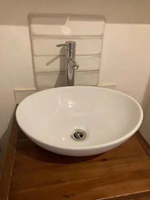 a white sink in a bathroom with aaucet at Garden Retreat in Nine Mile Burn