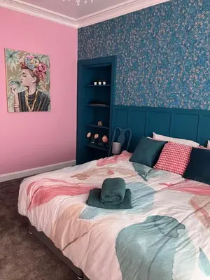 a bedroom with a large bed with a hat on it at The Gatehouse, 2 bedroom detached cottage in Beith