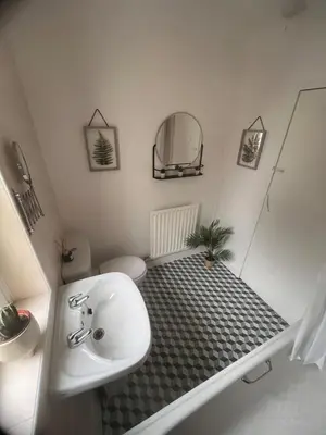 a bathroom with a sink and a toilet and a mirror at Mitchell House in Bellshill