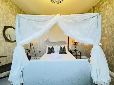 a bedroom with a blue bed with a canopy at Top Floor Getaway with Cozy Canopy Bed in Edinburgh