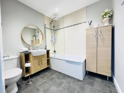 a bathroom with a sink and a toilet and a mirror at Top Floor Getaway with Cozy Canopy Bed in Edinburgh