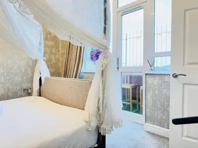 a bedroom with a canopy bed and a window at Top Floor Getaway with Cozy Canopy Bed in Edinburgh