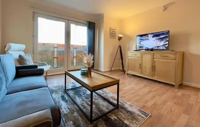 a living room with a couch and a tv at Sleek & Modern 2BR - Easy Access to City Centre in Glasgow