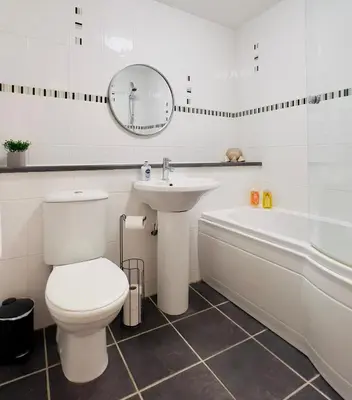 a bathroom with a toilet and a sink and a tub at Sleek & Modern 2BR - Easy Access to City Centre in Glasgow