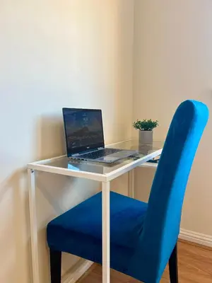 a desk with a blue chair with a laptop on it at Sleek & Modern 2BR - Easy Access to City Centre in Glasgow