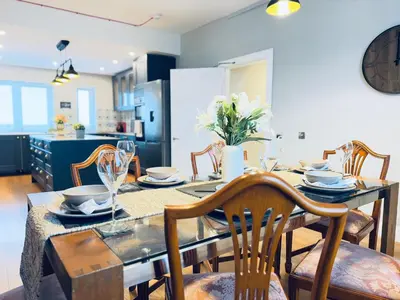 a dining room with a table and chairs and a kitchen at Top Floor Apartment with Castle Views in Edinburgh