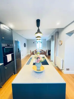 a kitchen with a table with a vase of flowers on it at Top Floor Apartment with Castle Views in Edinburgh