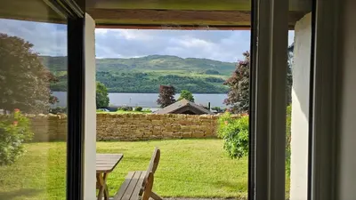 a window with a view of a lake from a house at Ivy Tree Cottage in Morenish