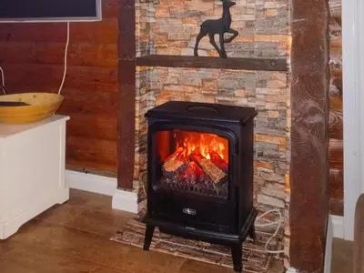 a stove in a room with a brick fireplace at Grouse Lodge in Dunoon