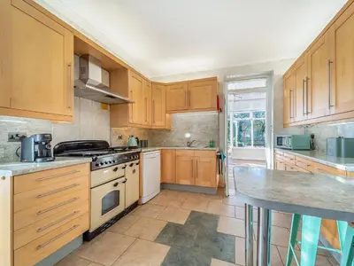 a kitchen with wooden cabinets and a stove top oven at Torland in Dalserf