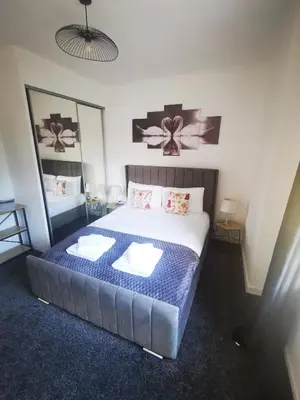 a bedroom with a large bed with two pillows at Blanca apartment - free parking! in Oban