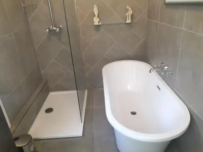 a bathroom with a toilet and a glass shower at Park Cottage - Spacious & Luxurious Room in B Listed Cottage in Moffat