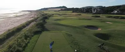 a man swinging a golf club on a golf course at West Coast Home From Home in Stevenston