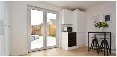 a kitchen with a sliding glass door leading to a patio at West Coast Home From Home in Stevenston
