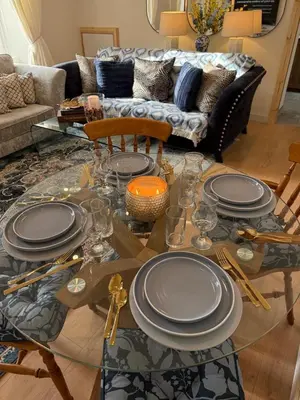 a living room with a glass table with plates on it at Home away from home in Glasgow - Free Street Parking in Mansewood