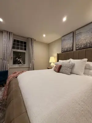 a bedroom with a large white bed and a window at Home away from home in Glasgow - Free Street Parking in Mansewood