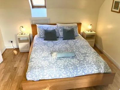 a bedroom with a large bed with two night stands at Cosy Karibu cottage with stunning canal views in Cairnbaan