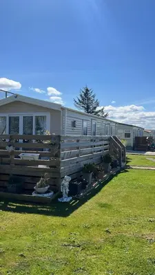 a mobile home with a fence and some plants at The Linwood at StrathavonRentals in Girvan